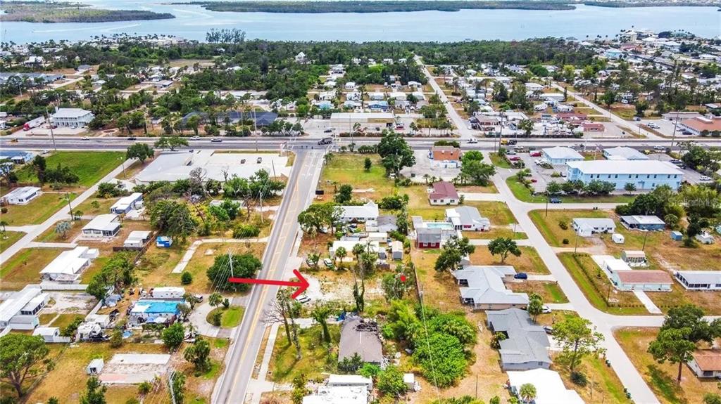 An aerial view shows a vacant lot marked by a red arrow in a neighborhood — 7439 SAN CASA DRIVE, ENGLEWOOD, FL