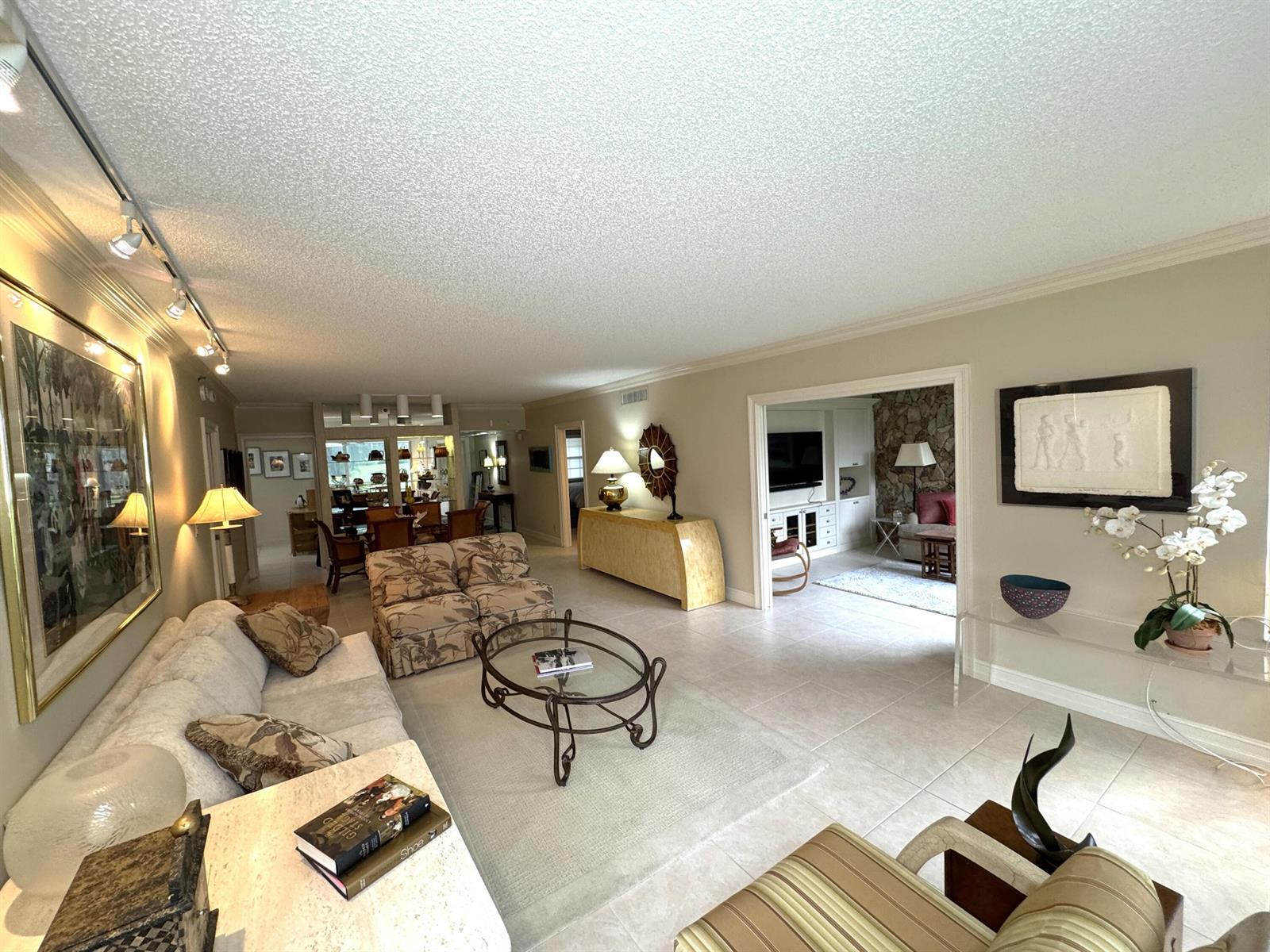 A spacious living room features tile floors, a popcorn ceiling, and an adjacent dining area — 625 Oaks Drive # 106, Pompano Beach FL 33069, POMPANO BEACH, FL