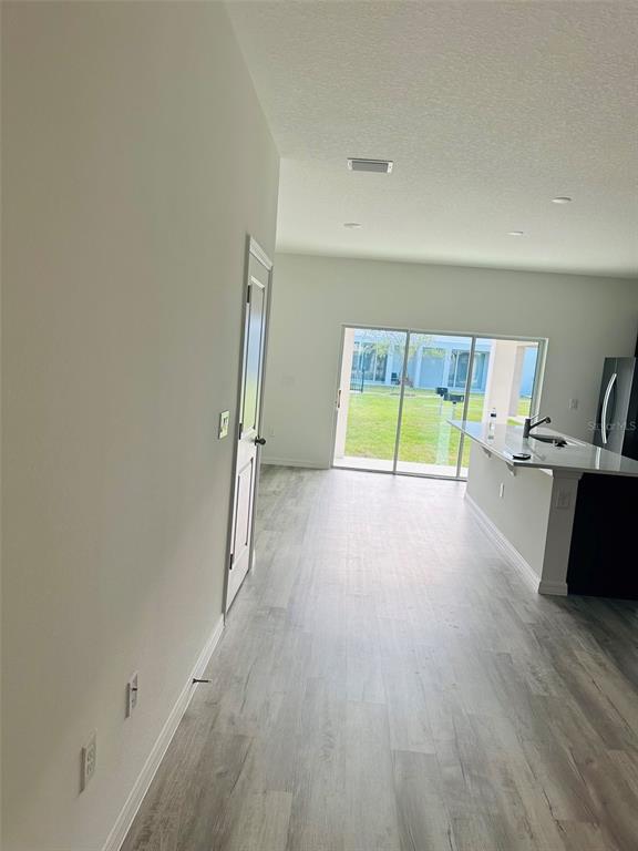 An open-concept kitchen with a breakfast bar overlooks a backyard through large sliding glass doors — 737 MAPLE OAK DRIVE, DELAND, FL