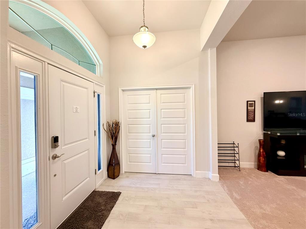 An entryway features a white front door, a double-door closet, and light-colored tile flooring — 9832 SW 46TH COURT, OCALA, FL