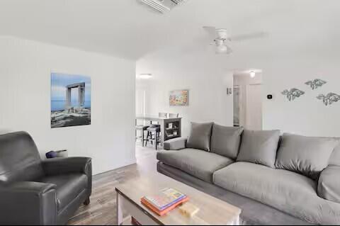 A living room features a gray sofa, a leather armchair, and a wooden coffee table — 1519 Treemont Avenue, Jupiter FL 33469, JUPITER, FL