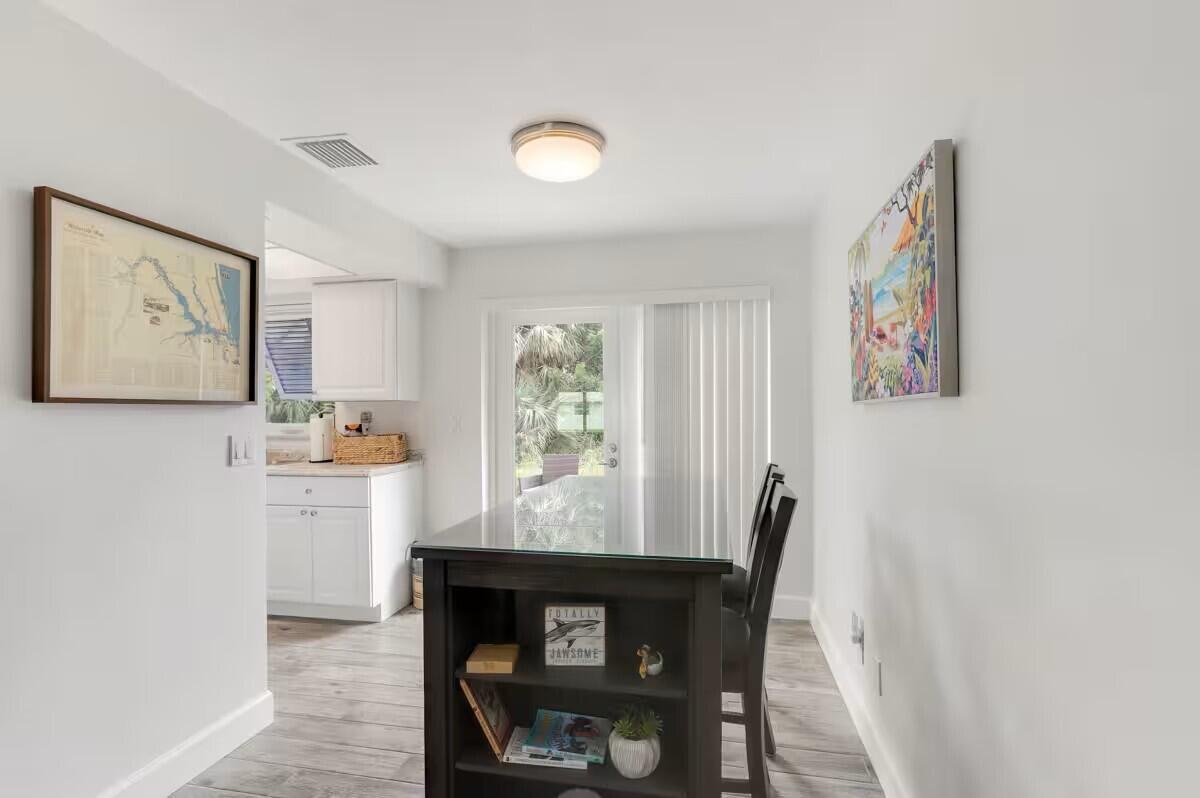 A dining area features a dark wood table with built-in shelving and light-colored flooring — 1519 Treemont Avenue, Jupiter FL 33469, JUPITER, FL