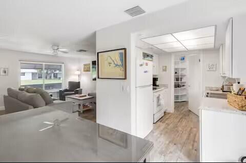 A view from a kitchen counter looking into a living room with gray furniture — 1519 Treemont Avenue, Jupiter FL 33469, JUPITER, FL