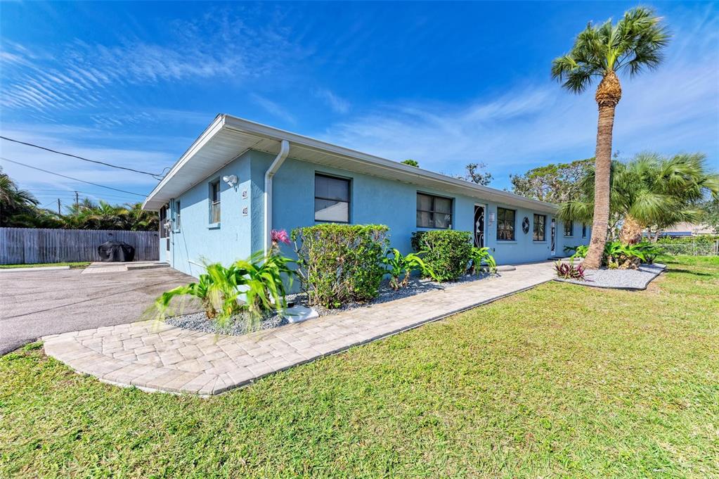 A light blue single-story building features a paved walkway and a tall palm tree — 401 SHORE ROAD, NOKOMIS, FL