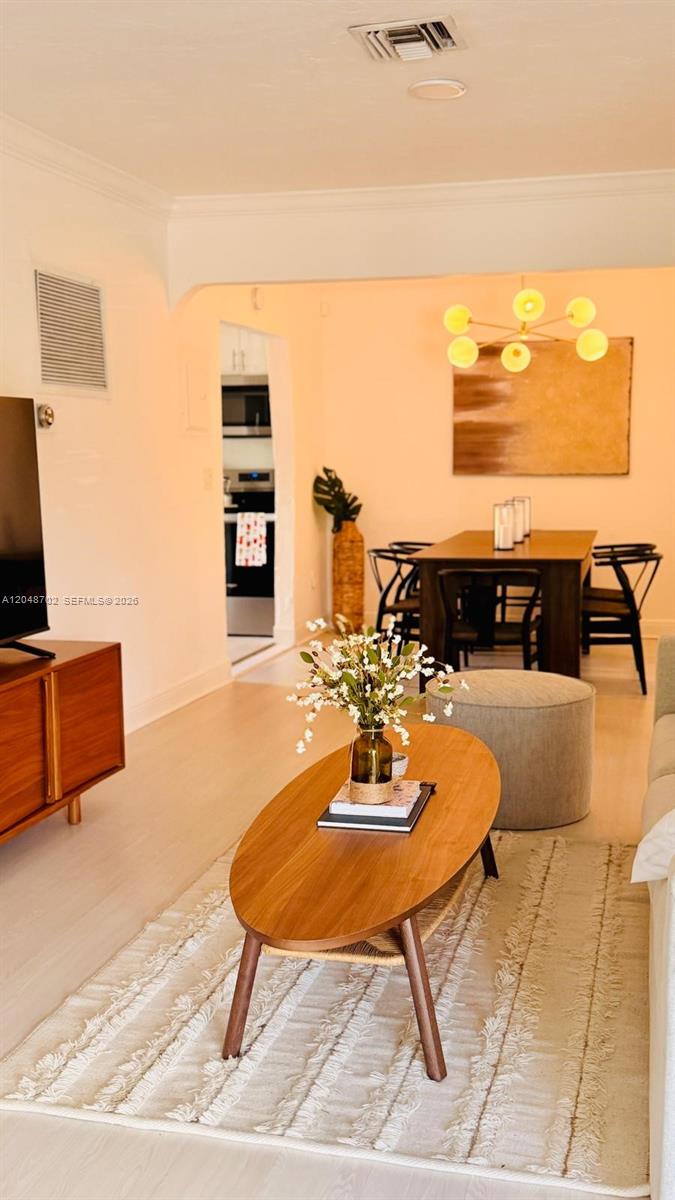 A living room features a wooden coffee table, a textured rug, and an adjacent dining area — HOLLYWOOD, FL