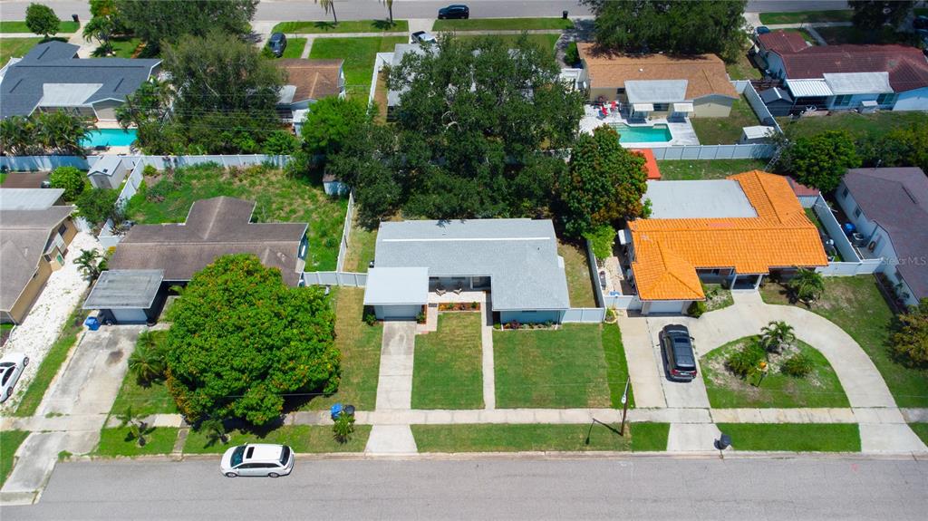 An aerial view shows a residential street with several single-story houses, driveways, and green lawns — 5919 33RD AVENUE N, ST PETERSBURG, FL