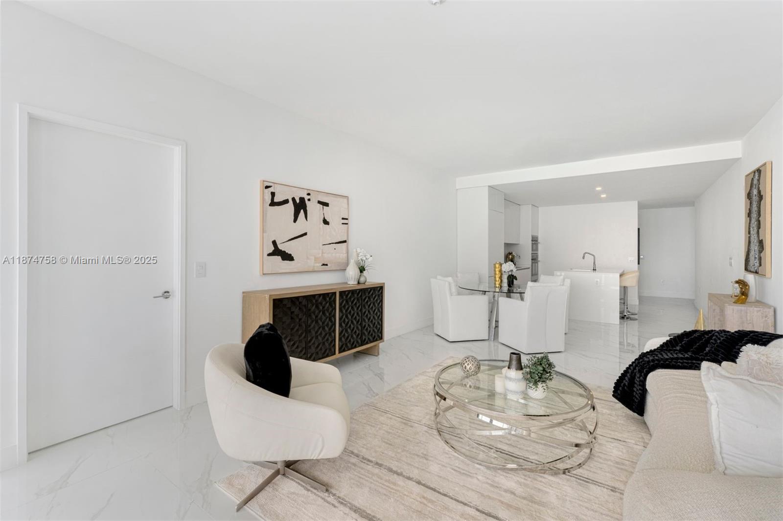 A bright, open-concept living and dining area features white marble floors and modern neutral furniture — 700 NE 24th St # 1005, Miami FL 33137, MIAMI, FL