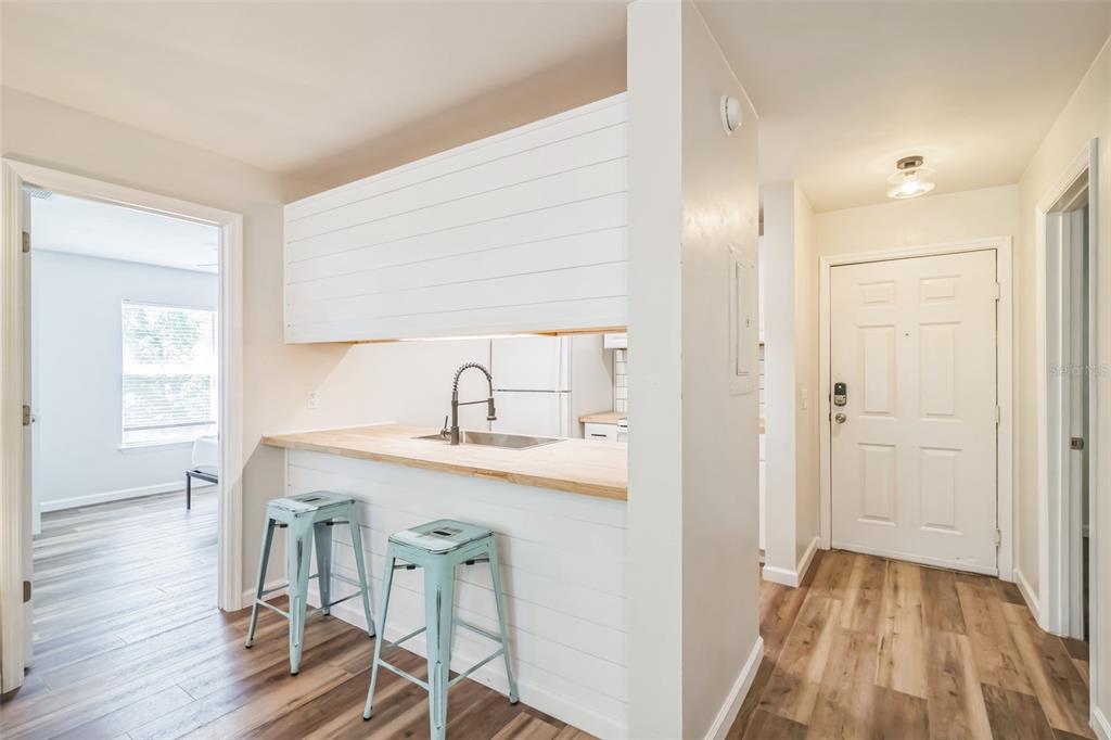 A kitchen pass-through with a wood countertop and two light blue metal stools — 3800 SW 20TH AVENUE UNIT 112, GAINESVILLE, FL