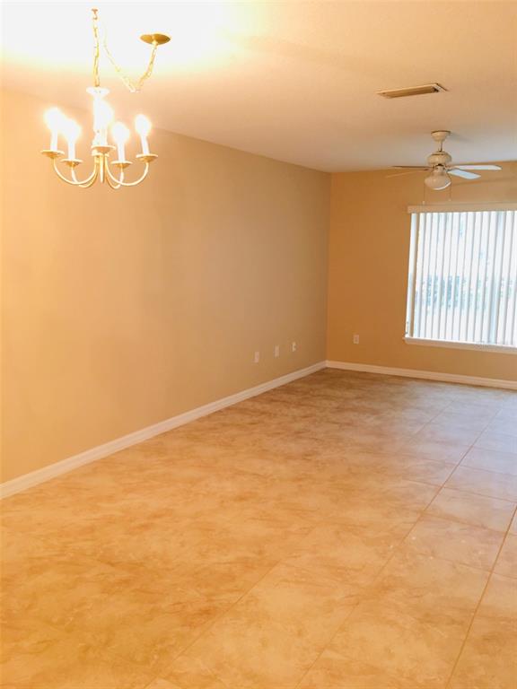 An empty room with tan tile flooring, a chandelier, and a ceiling fan — 2764 CLUB CORTILE CIRCLE, KISSIMMEE, FL