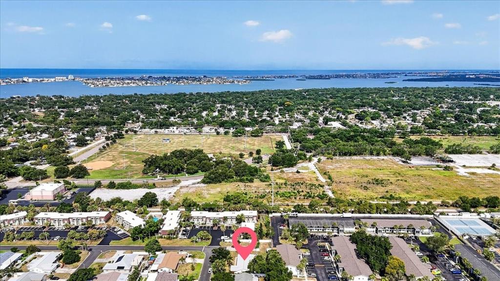 An aerial view shows a residential neighborhood with a pink location marker over a building — 6999 16TH AVENUE N, ST PETERSBURG, FL