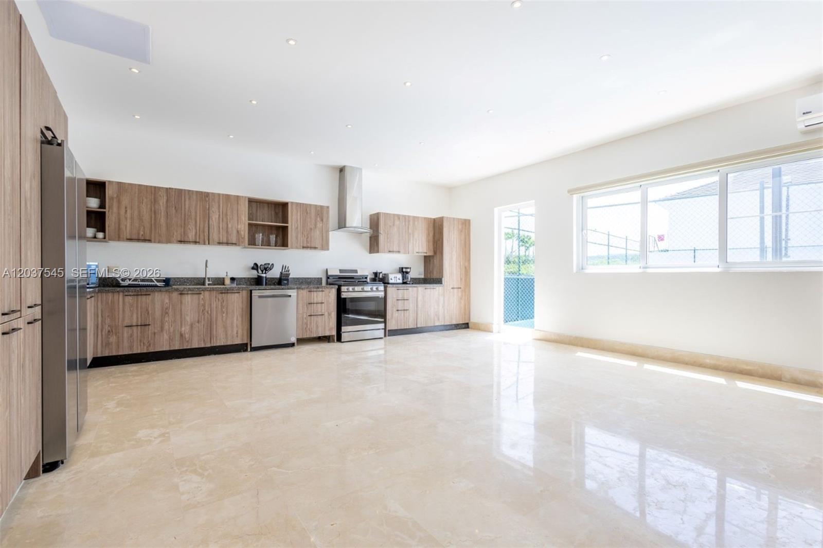 A modern kitchen features light wood cabinets, stainless steel appliances, and polished stone flooring — 0 la palmass, FL
