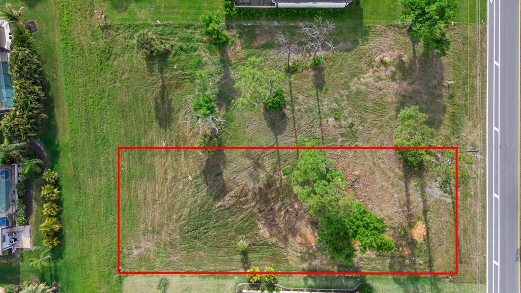 An aerial view of a rectangular, grassy vacant lot with several trees — 170 ROTONDA BOULEVARD E, ROTONDA WEST, FL