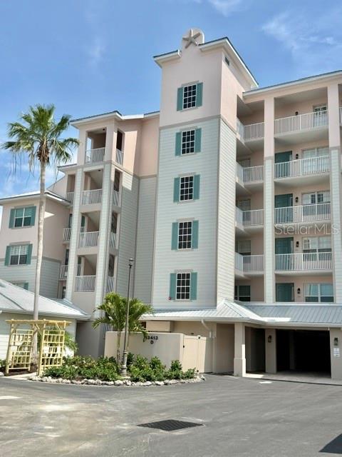 A multi-story residential building features light-colored siding, balconies, and a central tower with a star — 13413 GASPARILLA ROAD UNIT 304, PLACIDA, FL