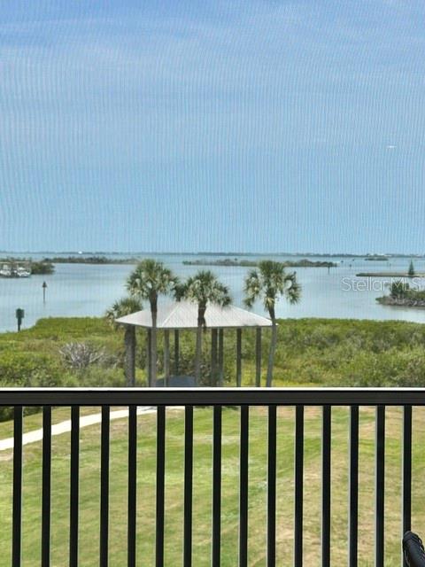 A view of a gazebo, palm trees, and a body of water from a balcony — 13413 GASPARILLA ROAD UNIT 304, PLACIDA, FL
