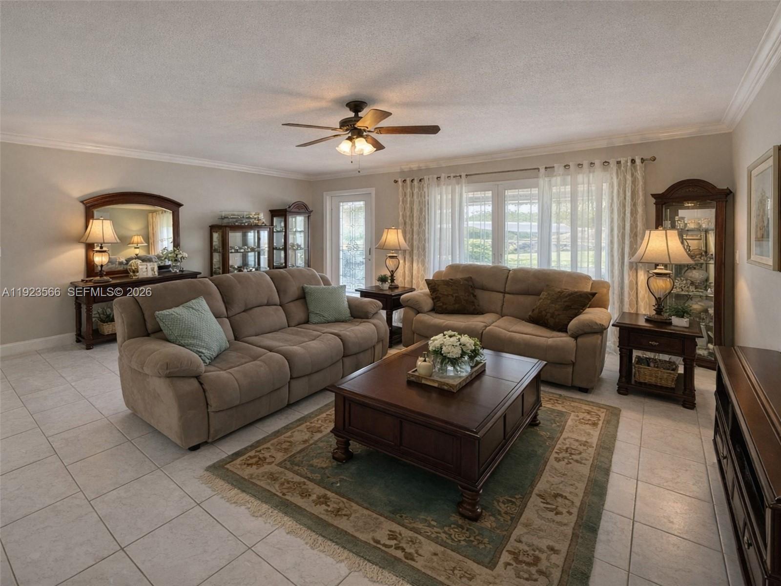 A living room features two beige sofas, a wooden coffee table, and tile flooring — 4208 NW 47th Ct, Tamarac FL 33319, TAMARAC, FL
