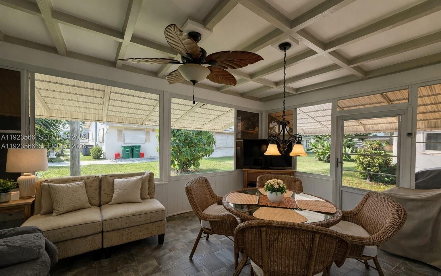 A sunroom features a coffered ceiling, wicker furniture, a dining set, and large screened windows — 4208 NW 47th Ct, Tamarac FL 33319, TAMARAC, FL