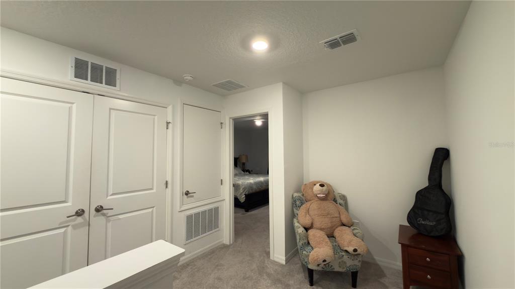 A carpeted landing area features a teddy bear in an armchair and a guitar case — 2994 CANARY AVENUE, DAVENPORT, FL