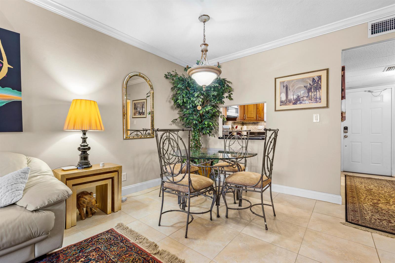 A dining area features a glass table with metal chairs, a chandelier, and a pass-through window — 400 NE 20th Street # B204, Boca Raton FL 33431, BOCA RATON, FL
