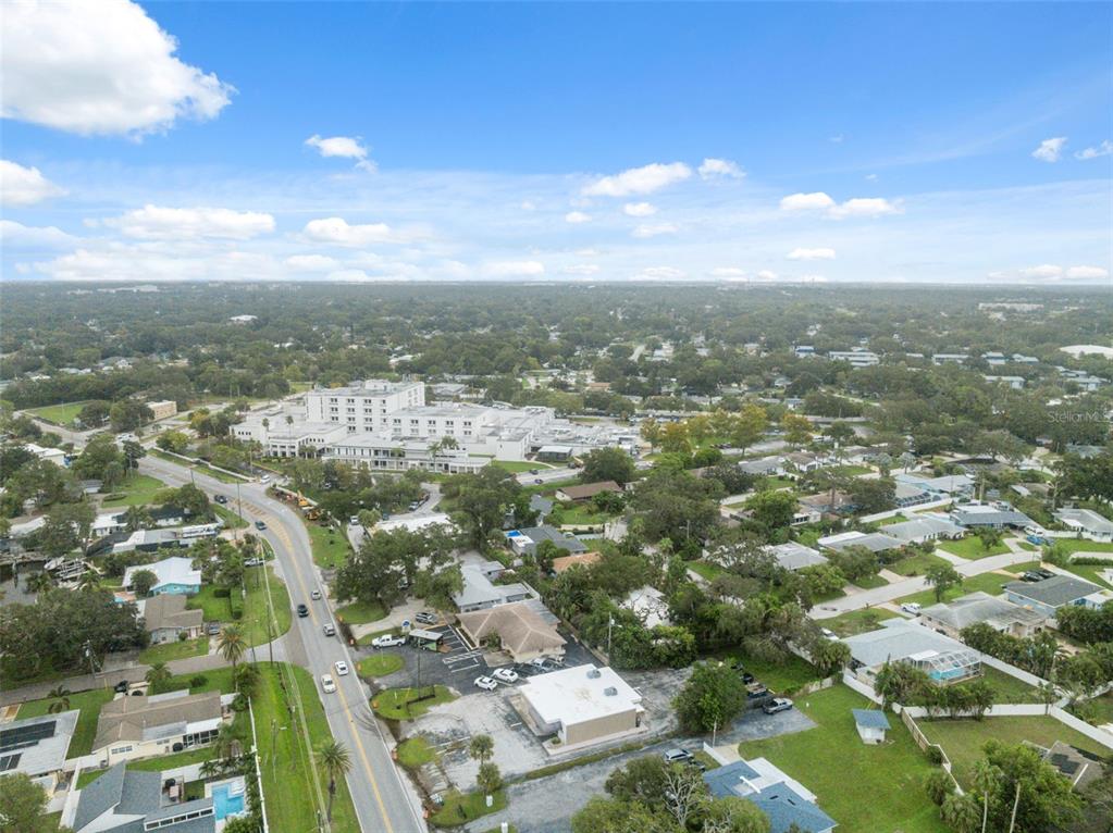 An aerial view shows a suburban neighborhood with a large hospital complex in the distance — 2101 INDIAN ROCKS ROAD S, LARGO, FL