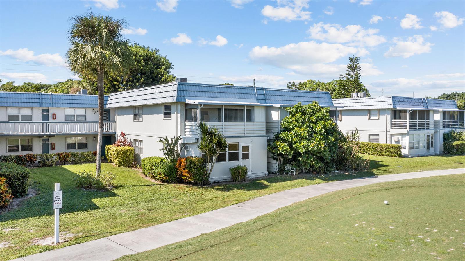 An exterior view of two-story apartment buildings adjacent to a golf course fairway — 106 Tuscany B, Delray Beach FL 33446, DELRAY BEACH, FL