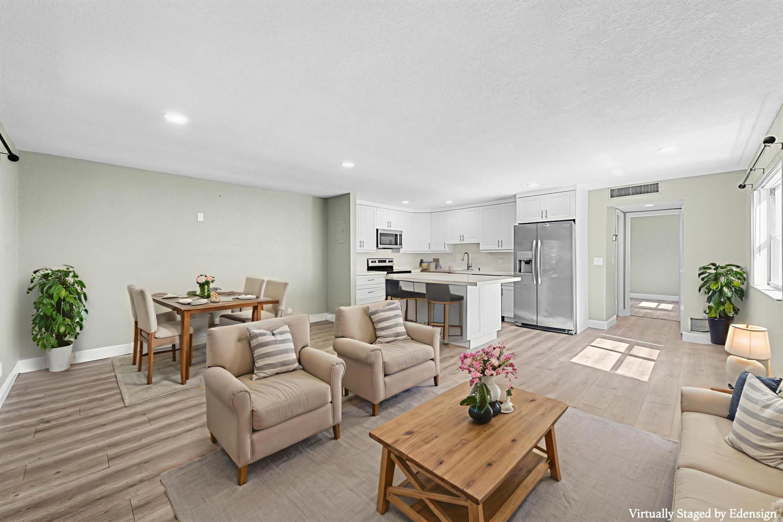 This virtually staged open-concept living and dining area features light wood flooring and white cabinetry — 106 Tuscany B, Delray Beach FL 33446, DELRAY BEACH, FL
