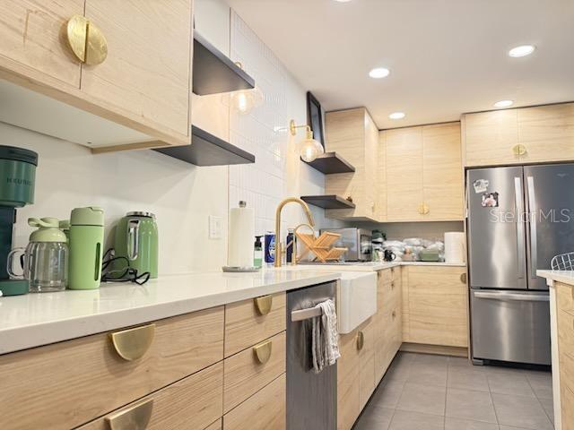 A kitchen features light wood cabinets, gold hardware, white countertops, and stainless steel appliances — 1717 NW 23RD AVENUE UNIT GA, GAINESVILLE, FL