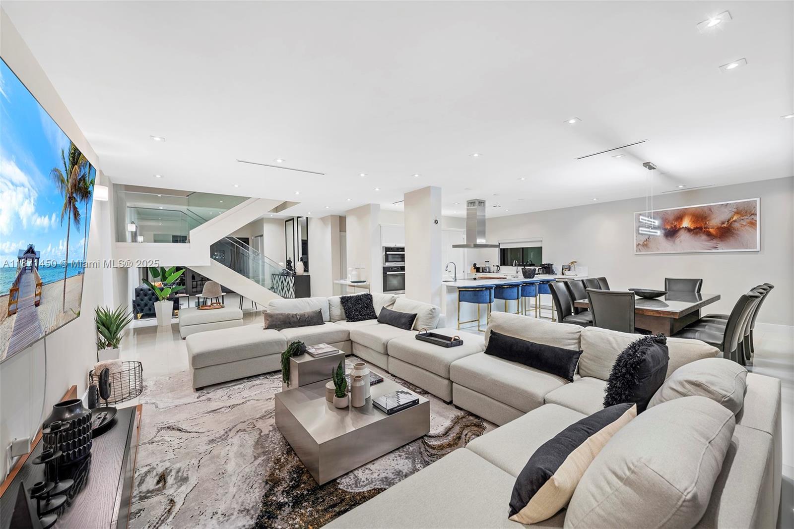 A modern open-concept living room features a large sectional sofa, dining area, and kitchen — 850 Washington St, Hollywood FL 33019, HOLLYWOOD, FL