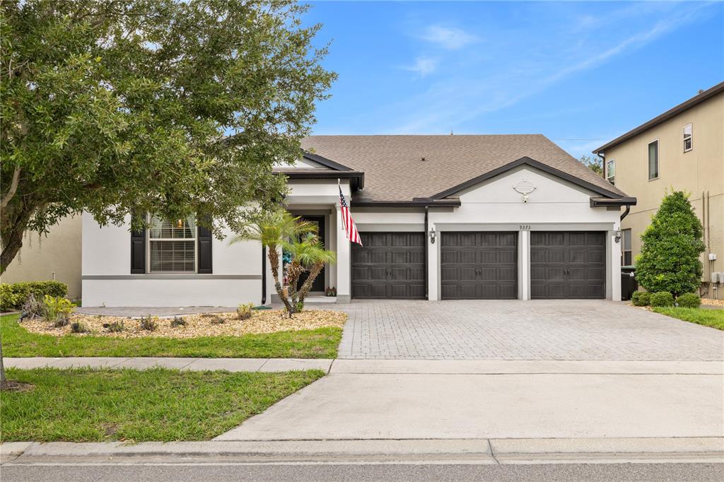 A single-story house with a three-car garage, a paved driveway, and a front yard — 9373 ROYAL ESTATES BOULEVARD, ORLANDO, FL