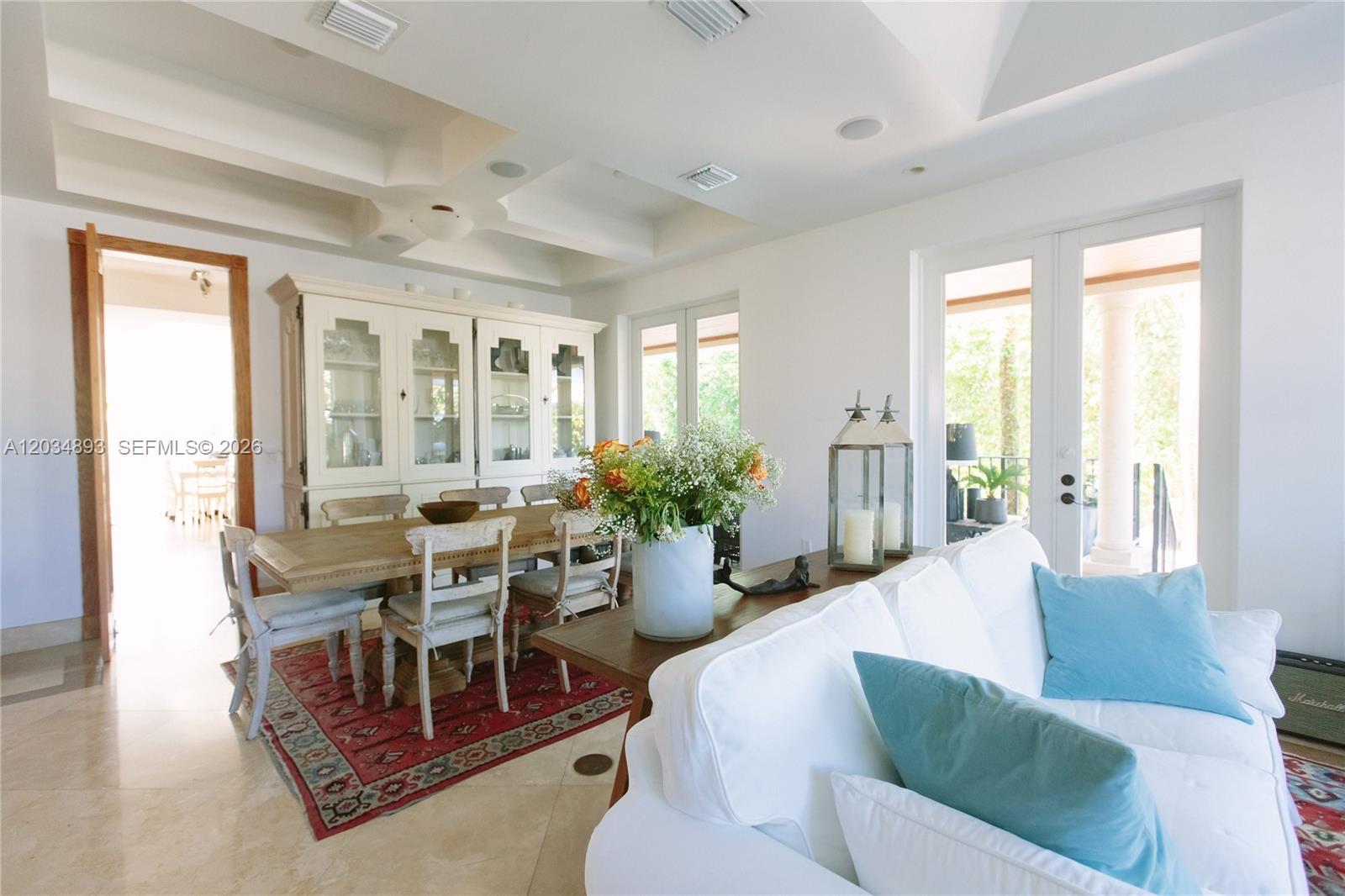 A dining area with a wooden table and hutch sits beside a white sofa — 335 W Enid Dr, Key Biscayne FL 33149, KEY BISCAYNE, FL