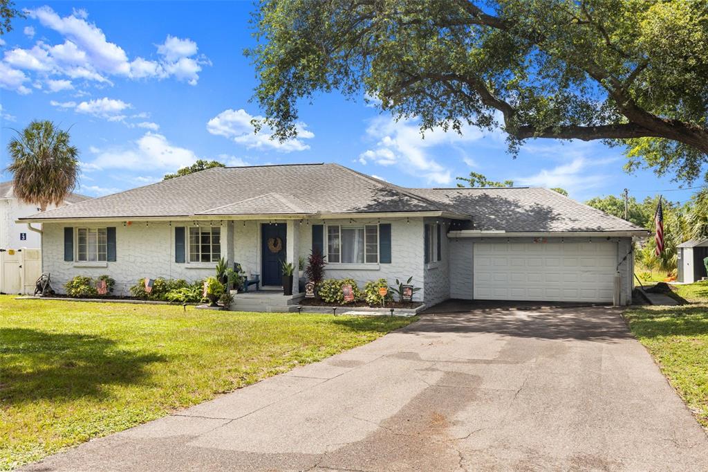 A single-story white brick house with blue shutters, a front porch, and an attached garage — 920 ALICIA AVENUE, TAMPA, FL