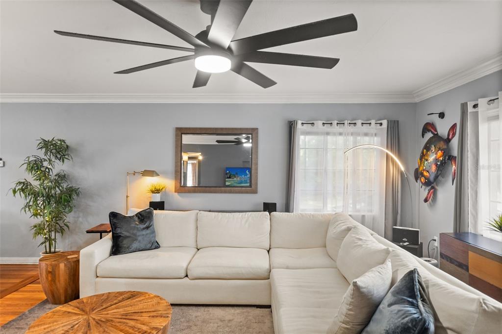 A living room features a white sectional sofa, a ceiling fan, and a wall mirror — 920 ALICIA AVENUE, TAMPA, FL