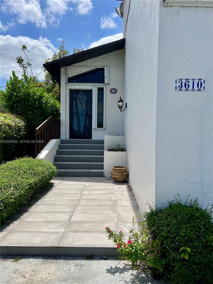The exterior view shows a white house entrance with a tiled walkway and front steps — 3610 SW 113th Pl, Miami FL 33165, MIAMI, FL