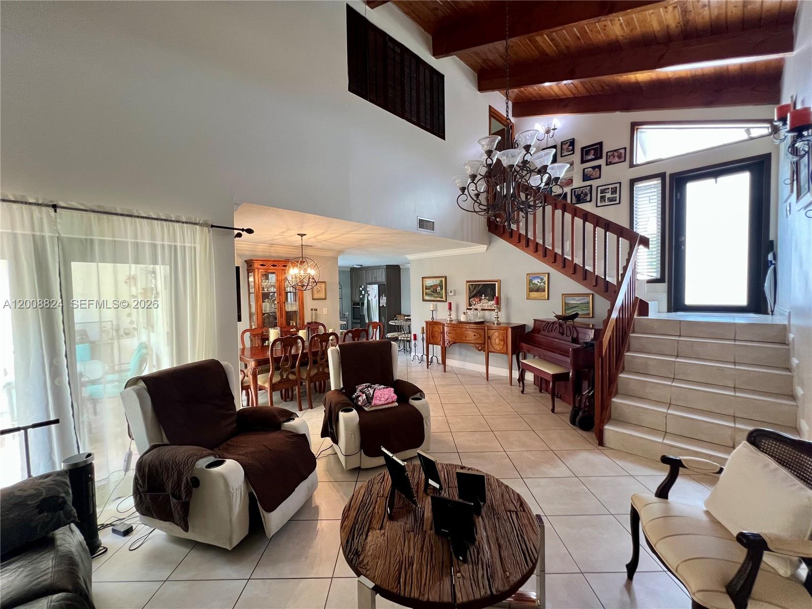 A living room with tile floors, a wooden staircase, and a vaulted wood-beamed ceiling — 3610 SW 113th Pl, Miami FL 33165, MIAMI, FL