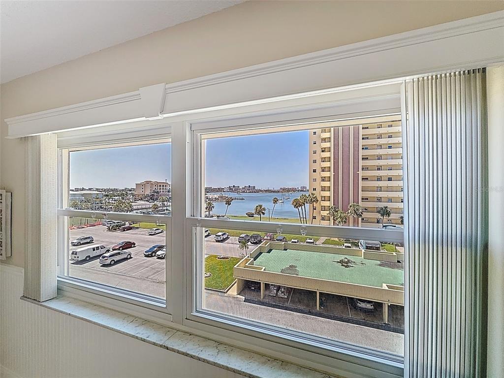 A view of a parking lot and waterfront from a window with white trim — 4550 COVE CIRCLE UNIT 507, ST PETERSBURG, FL