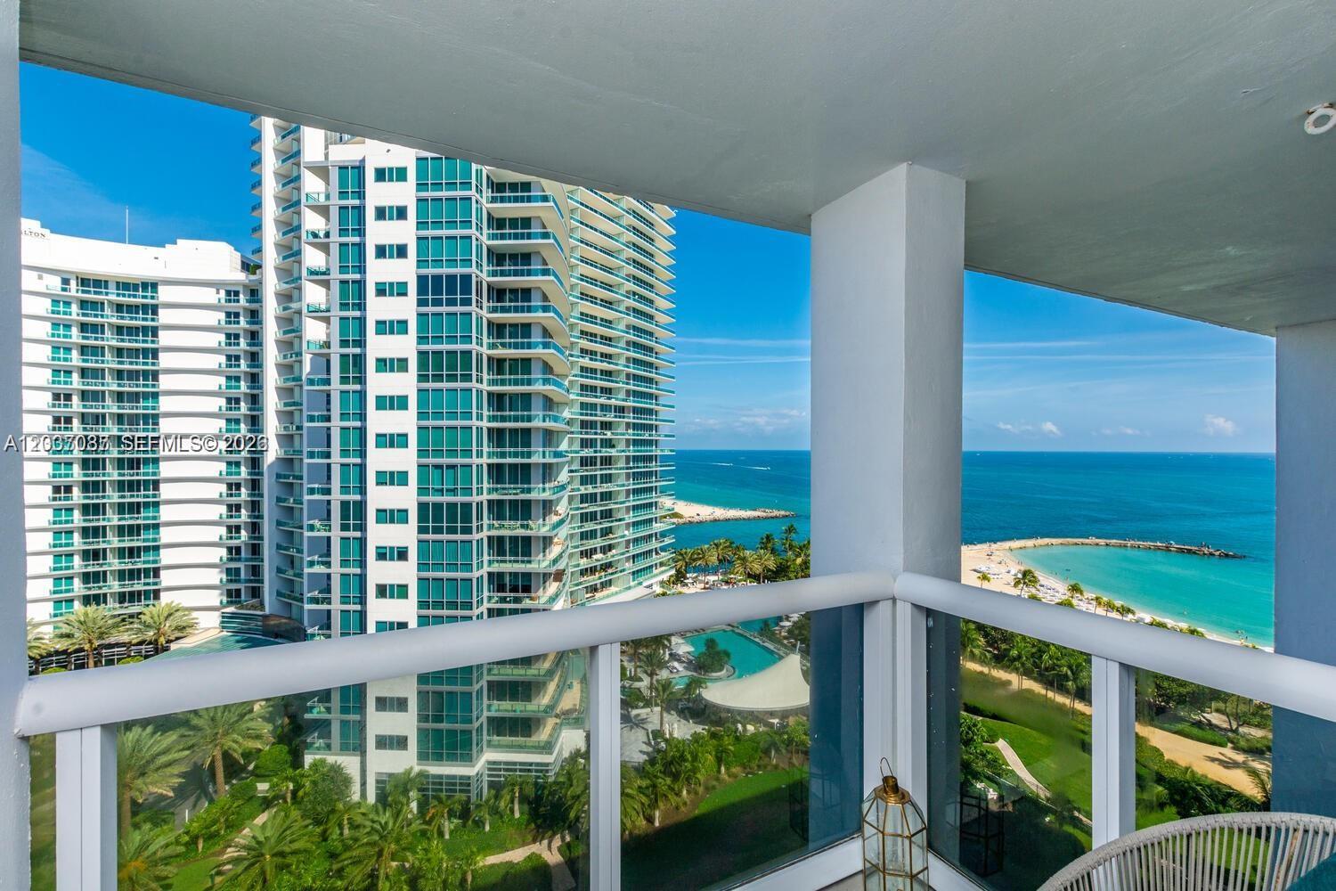 A balcony view overlooks a swimming pool, lush landscaping, a beach, and the ocean — 10275 Collins Ave # 1404, Bal Harbour FL 33154, BAL HARBOUR, FL