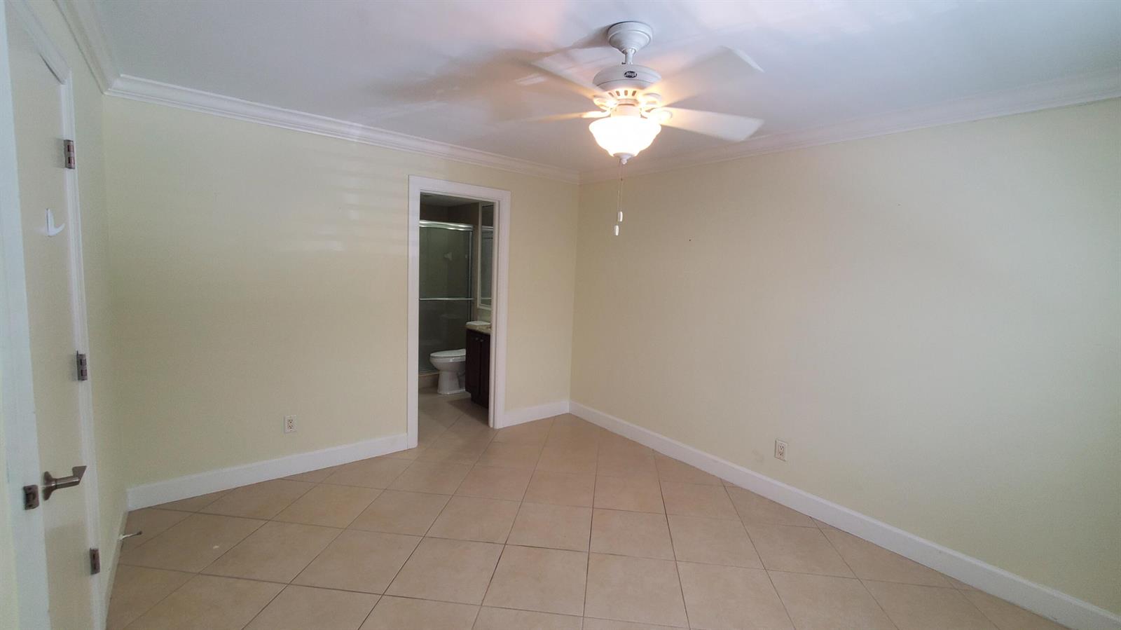 An empty room with light-colored walls, tile flooring, a ceiling fan, and an attached bathroom — 1727 HIGHWAY A1A Highway # 106, Vero Beach FL 32963, VERO BEACH, FL