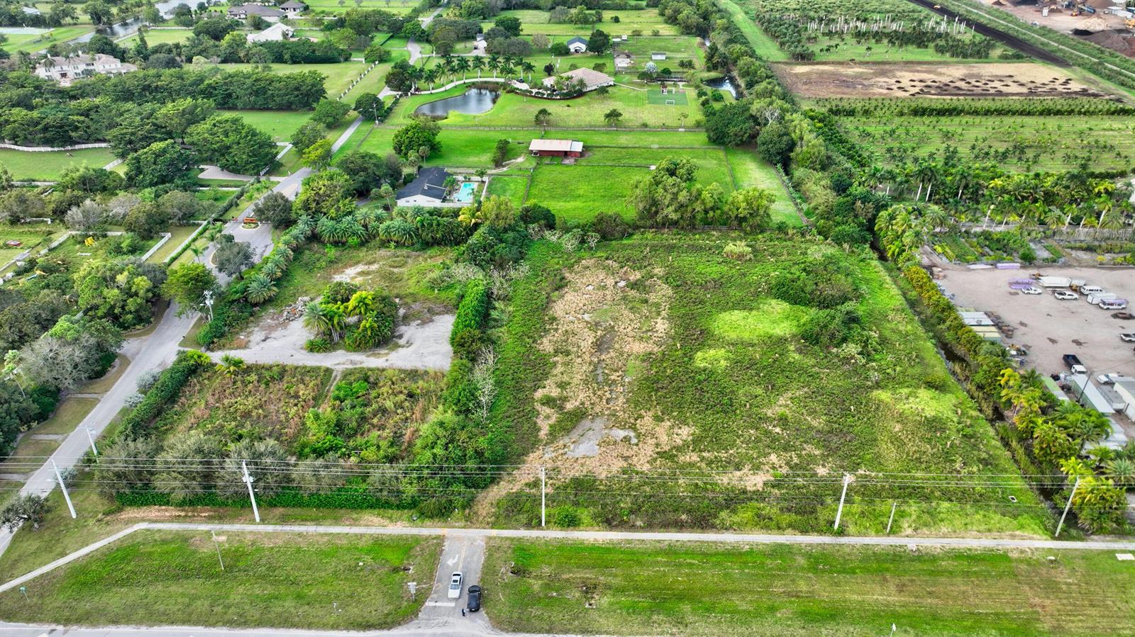 An aerial view shows a large, undeveloped rectangular lot with vegetation and adjacent residential properties — 15445 S State Road 7 Road, Delray Beach FL 33446, DELRAY BEACH, FL