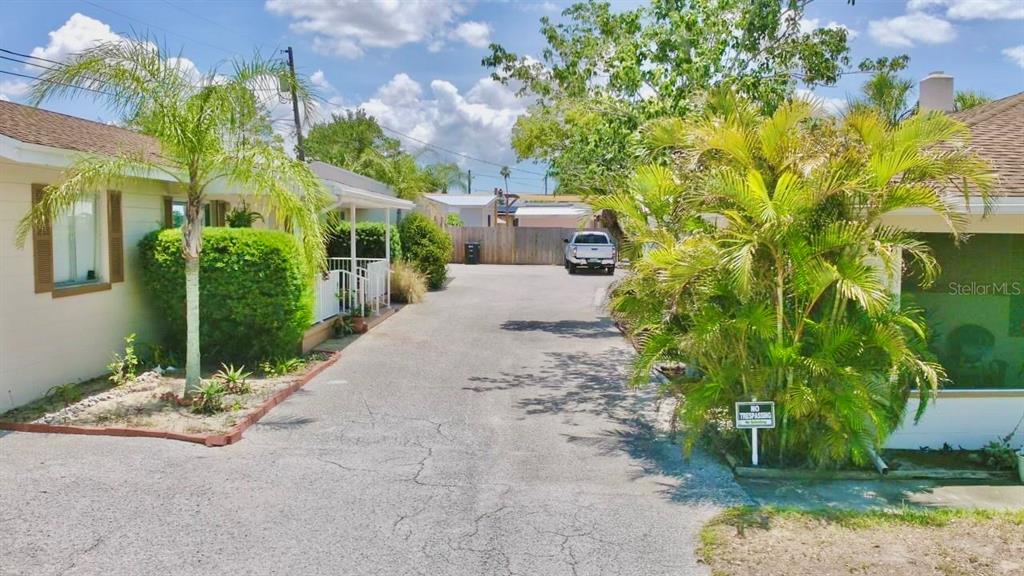 A paved driveway leads between two houses with palm trees and a no trespassing sign — 411 PLEASANT STREET, CLEARWATER, FL
