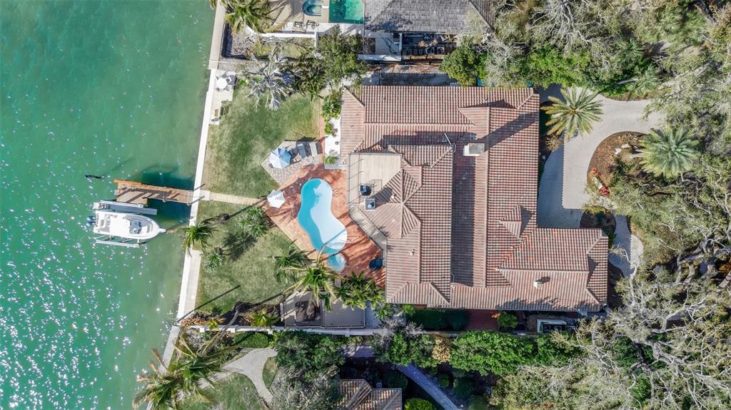 An aerial view of a waterfront home featuring a tiled roof, pool, and private dock — 1504 S LODGE DRIVE, SARASOTA, FL