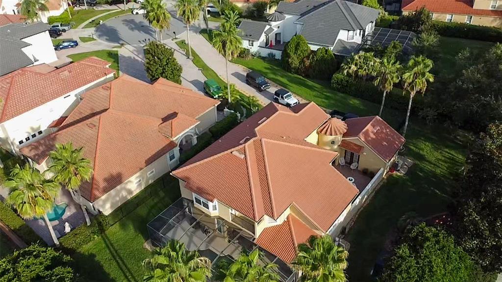 An aerial view shows two suburban houses with terracotta-colored tile roofs and screened-in pool enclosures — 11434 RAPALLO LANE, WINDERMERE, FL