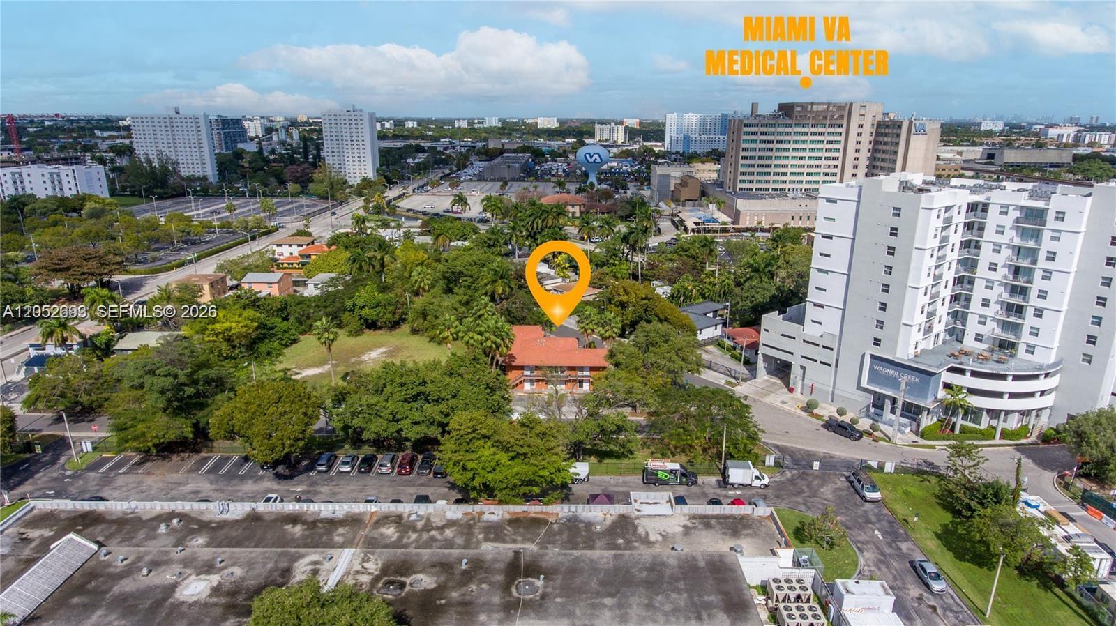 An aerial view shows a multi-story building surrounded by trees near a large medical center — 1333 NW 15th St # 10, Miami FL 33125, MIAMI, FL