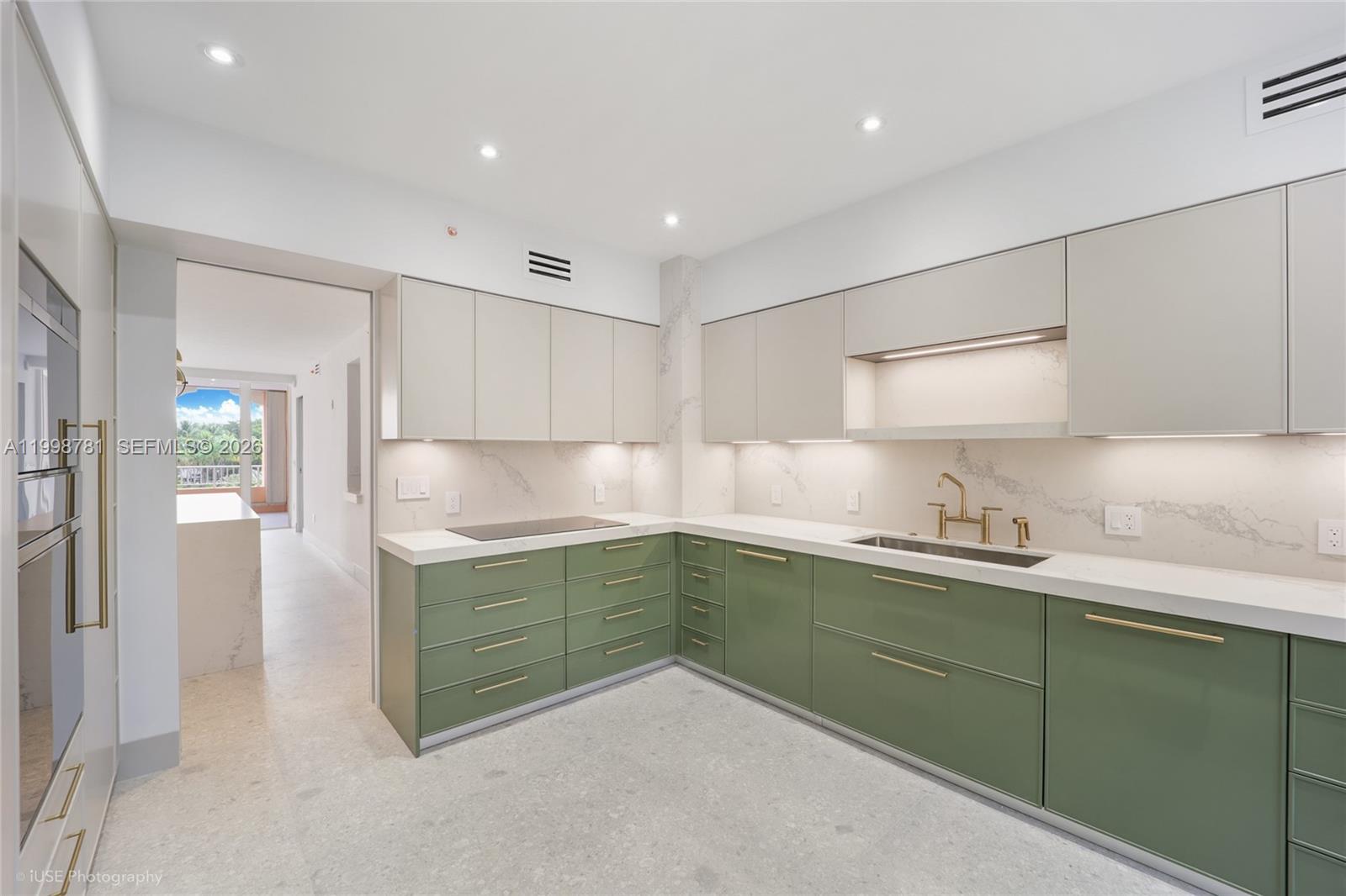 A modern kitchen features green lower cabinets, light upper cabinets, and white marble countertops — 737 Crandon Blvd # 301, Key Biscayne FL 33149, KEY BISCAYNE, FL