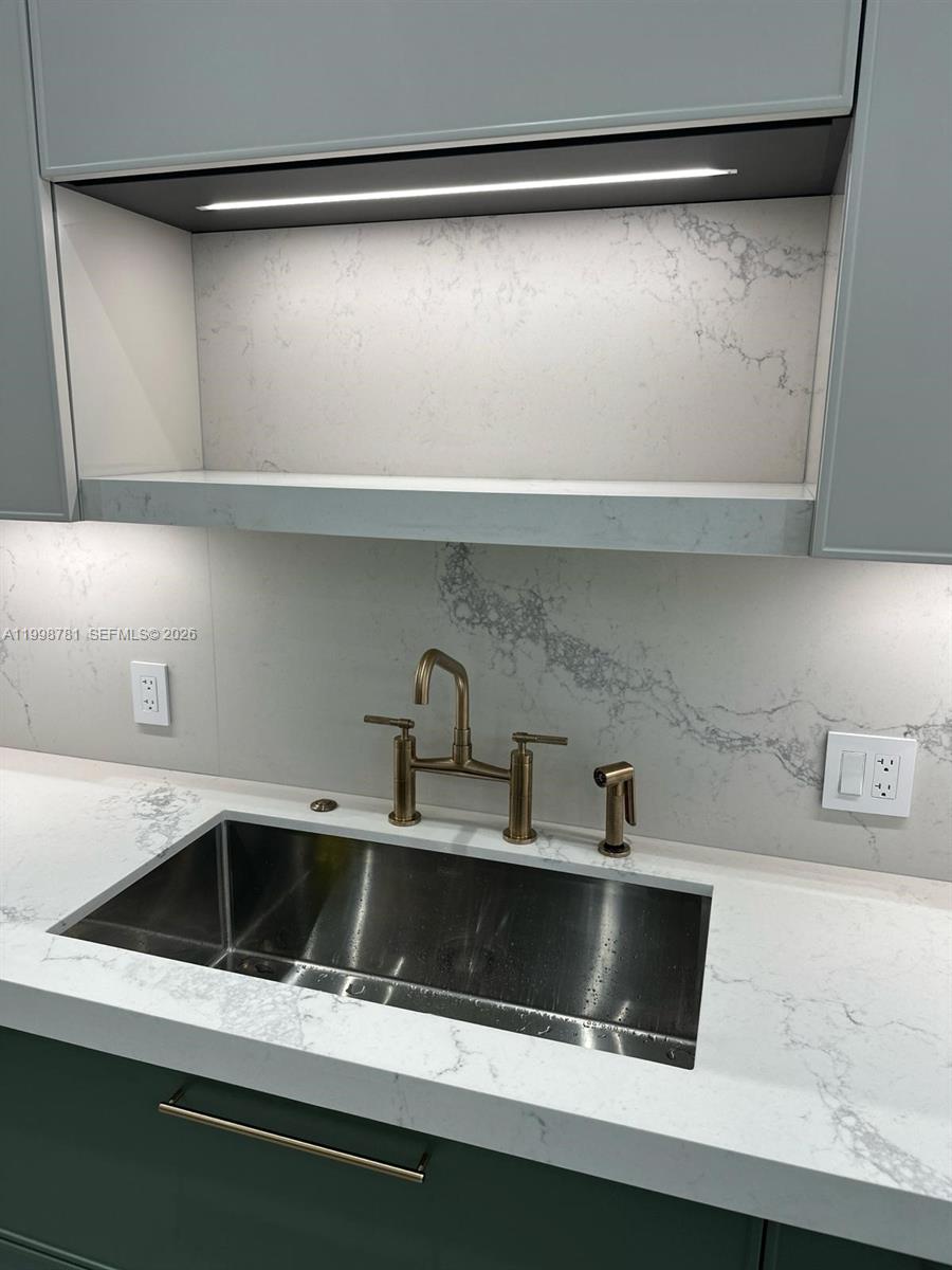 A kitchen sink with a gold faucet is set into a white marble countertop — 737 Crandon Blvd # 301, Key Biscayne FL 33149, KEY BISCAYNE, FL