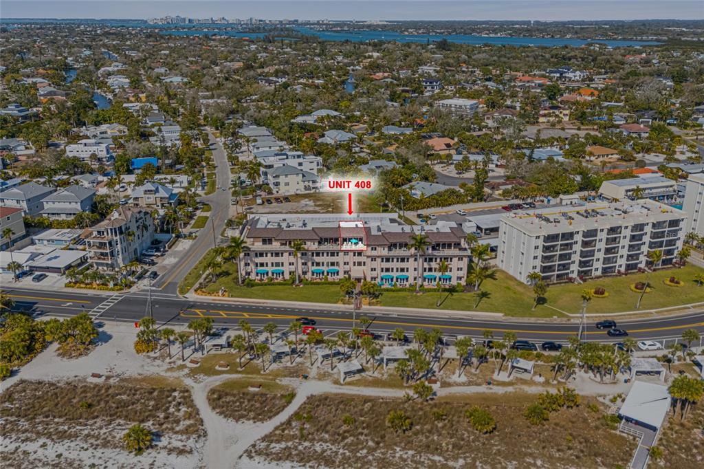 An aerial view shows a multi-story beachfront condominium building with a highlighted unit — 711 BEACH ROAD UNIT 408, SARASOTA, FL