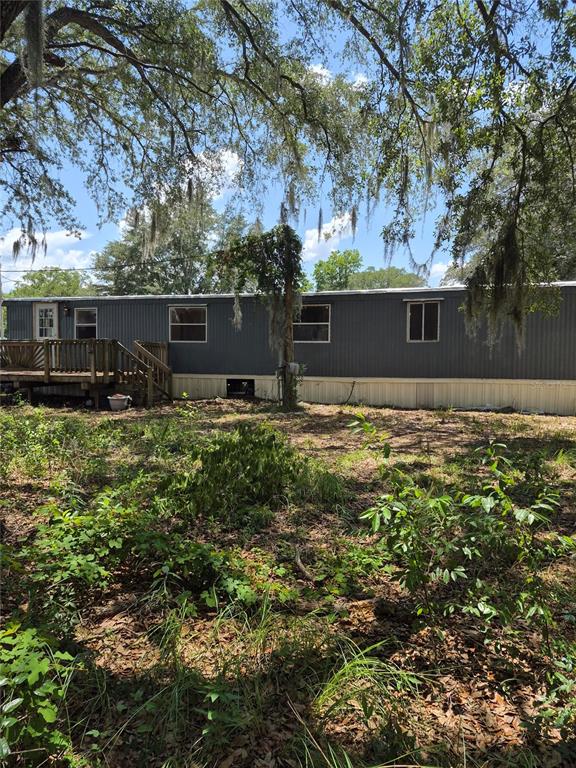 A kitchen with wood cabinets, a stainless steel stove, and unfinished plywood flooring — 9285 SE 140TH PLACE, SUMMERFIELD, FL