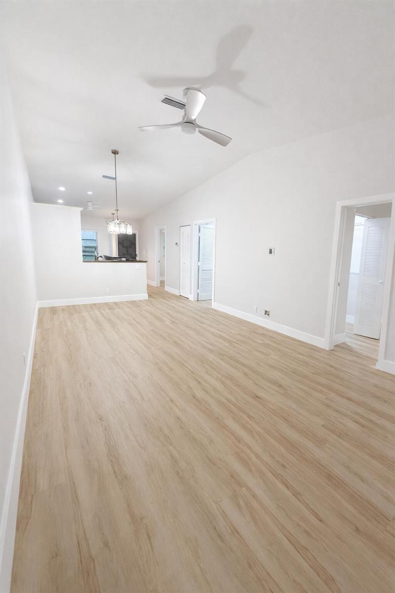 An empty room features light wood-look flooring, white walls, and a ceiling fan — 18765 Candlewick Drive, Boca Raton FL 33496, BOCA RATON, FL
