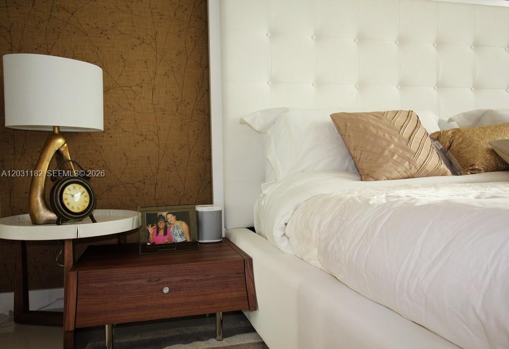 A bedroom features a white tufted headboard, a wooden nightstand, and a lamp — 7751 NW 107th Ave # 805, Doral FL 33178, DORAL, FL