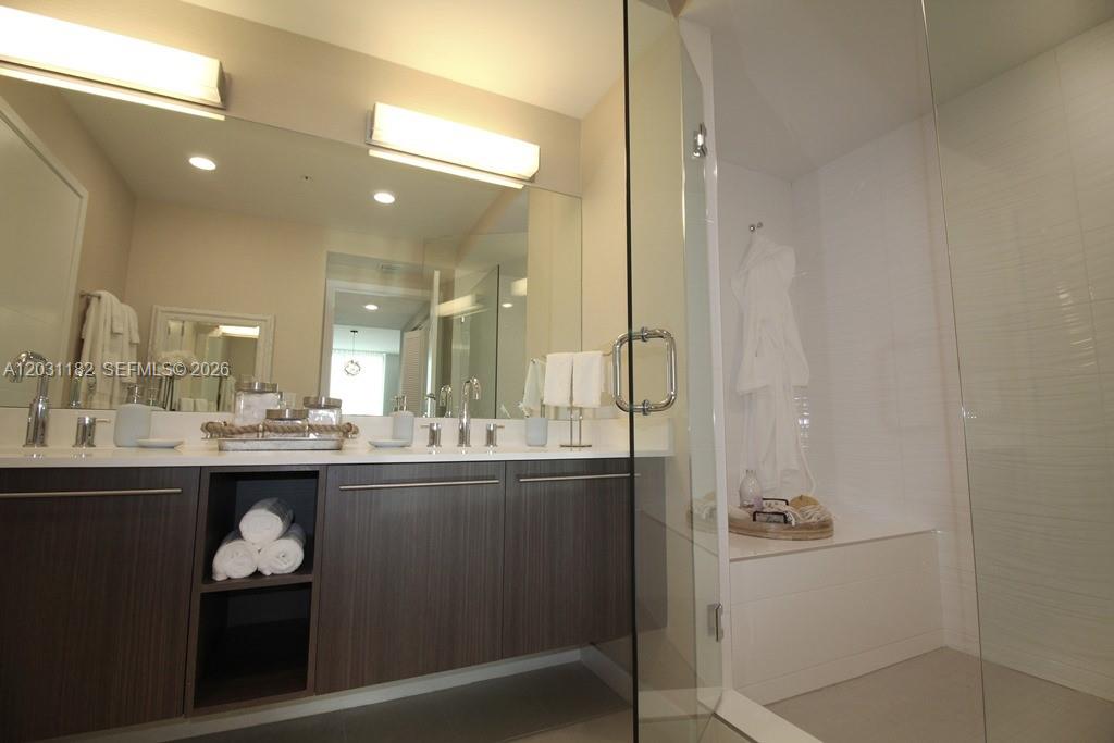 A modern bathroom features a dark wood vanity, a large mirror, and a glass-enclosed shower — 7751 NW 107th Ave # 805, Doral FL 33178, DORAL, FL