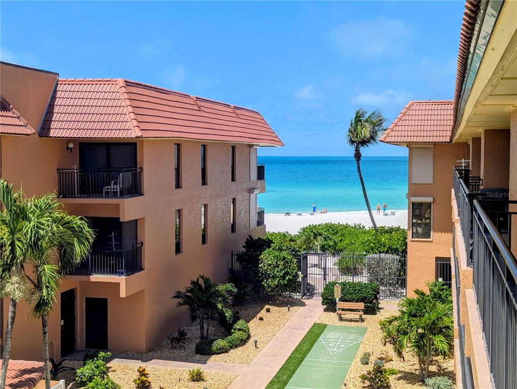 An exterior view of a beachside apartment complex with a shuffleboard court and ocean view — 6006 GULF DRIVE UNIT 207, HOLMES BEACH, FL
