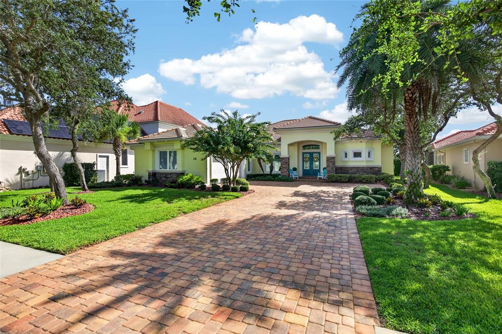 A single-story house with a paver driveway, light-colored stucco walls, and a tiled roof — 28 N WATERVIEW DRIVE, PALM COAST, FL